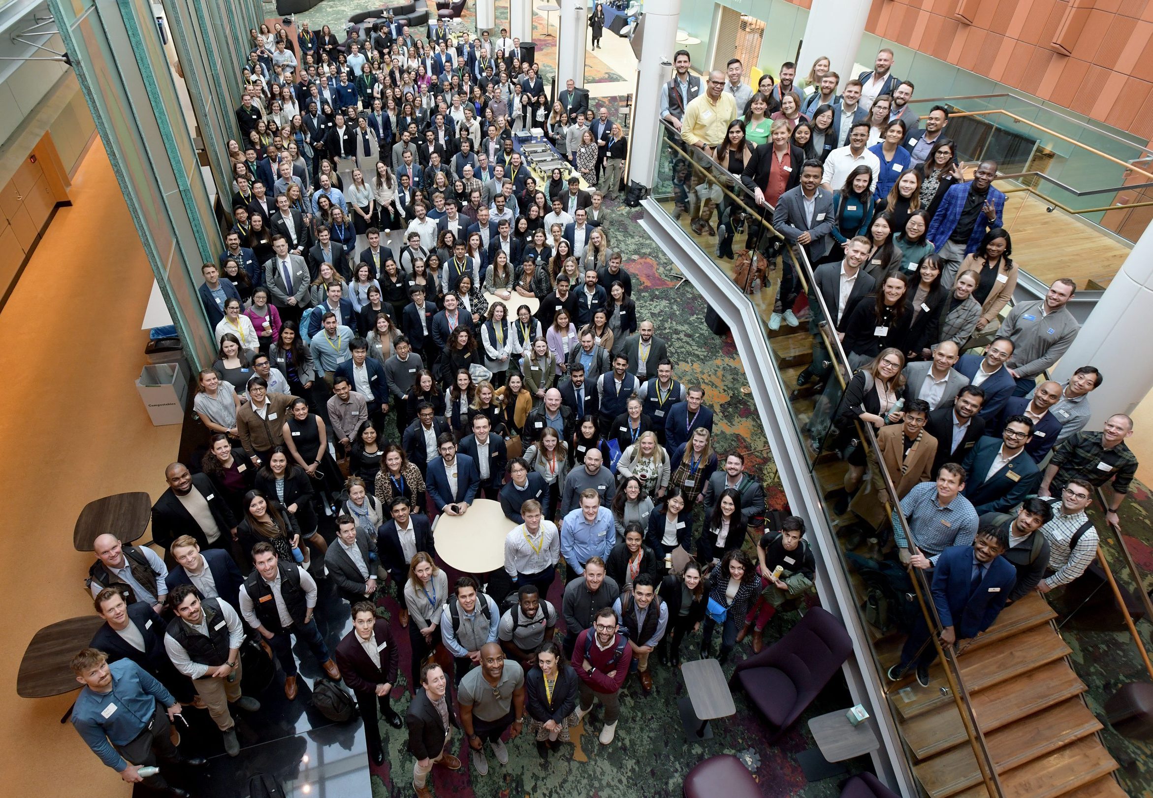 Conference attendees gathered for a group photo, as seen from one floor above.