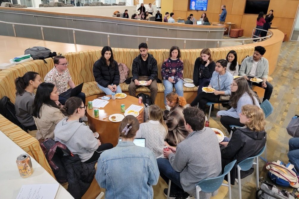 Students gather in a circle for discussion and dinner in the Gross Hall Energy Hub.