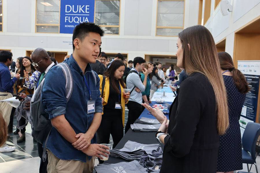 Students talking in Fuqua School of Business during Energy Week event.