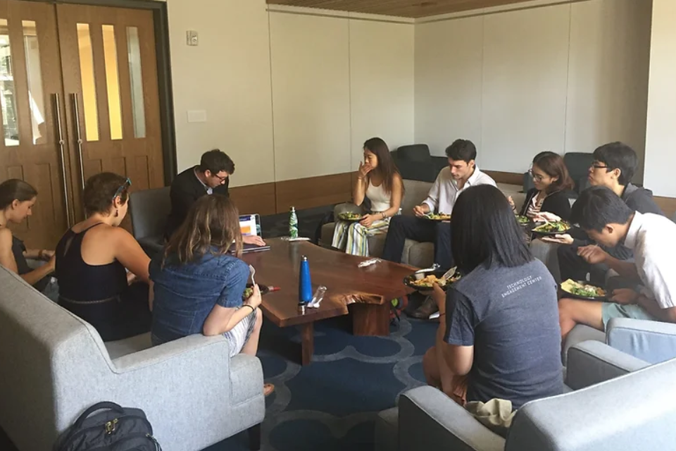 Student members of Duke Undergraduate Energy & Climate Club sitting in a circle while a student presents.