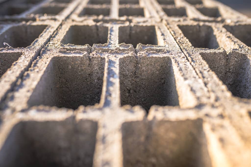 Concrete block bricks in stack for wall construction. Concrete block, cinder blocks, breeze blocks, hollow blocks, Besser blocks or Besser bricks wall background, brick texture.