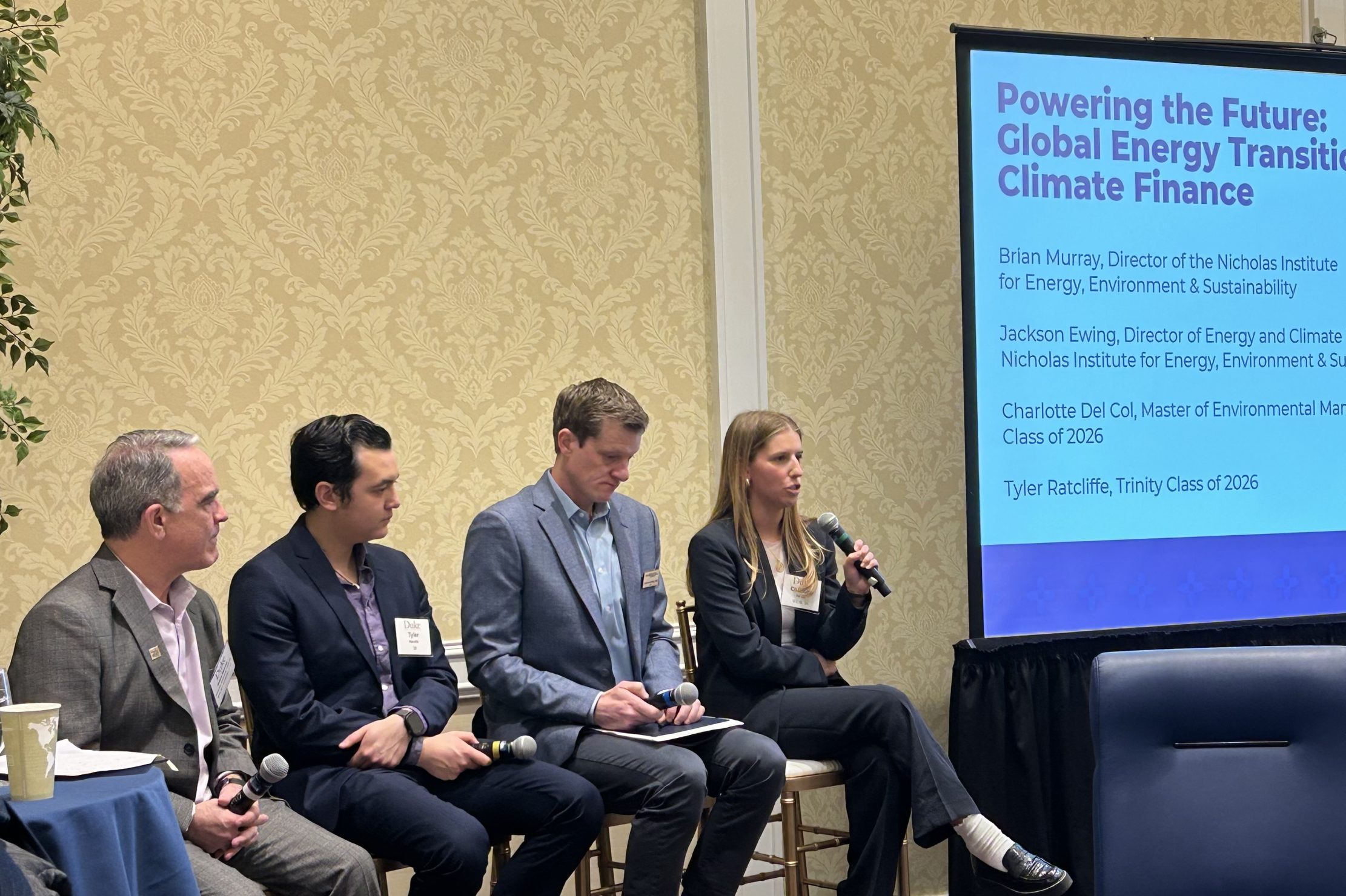 4 panelists seated in front of a screen giving a talk
