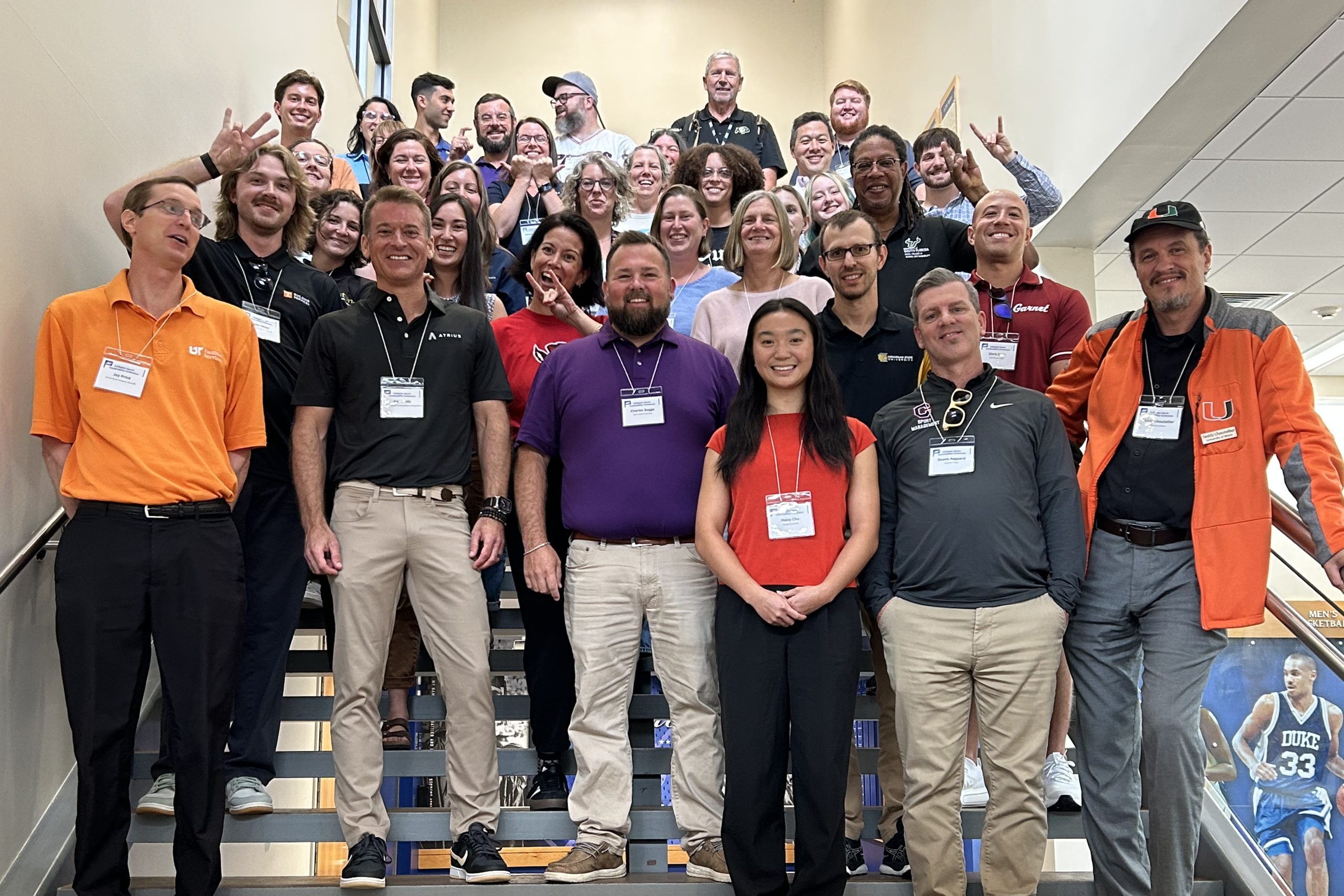 large group of sports sustainability professionals, athletes and coaches posing on steps