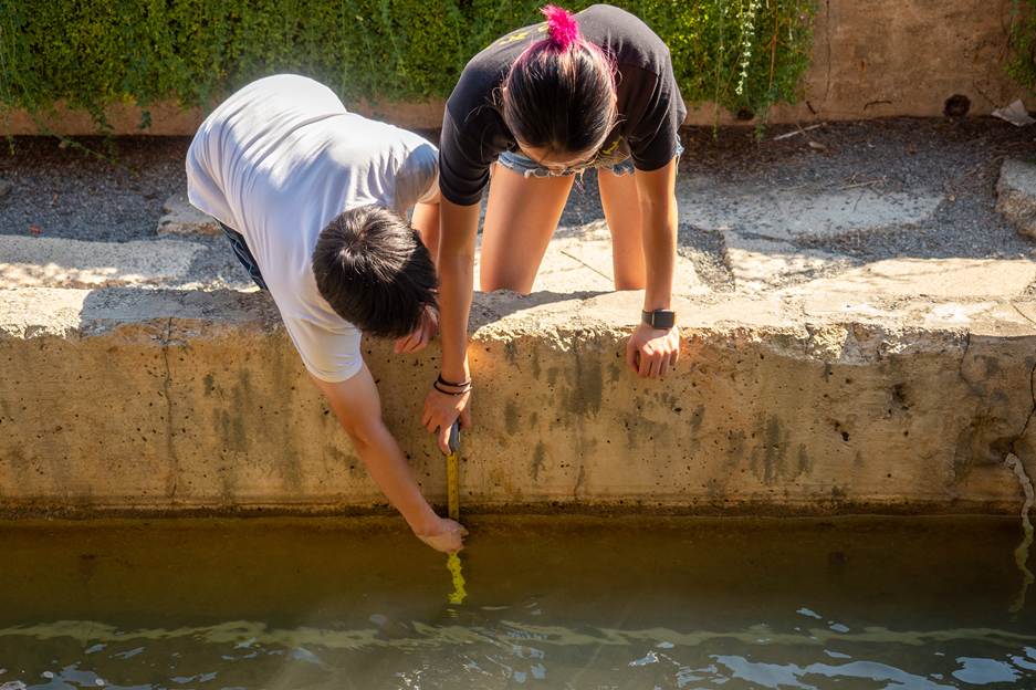 People reaching into the river